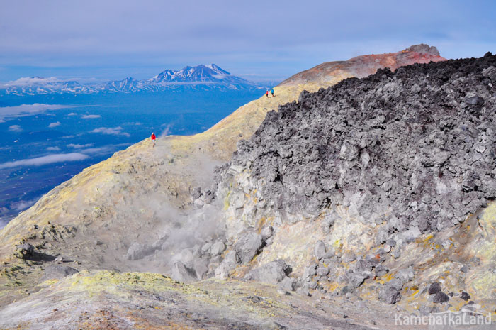 people walking on the edge of a volcano.